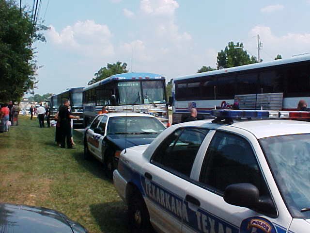 Police cruisers sit in front of the buses.
